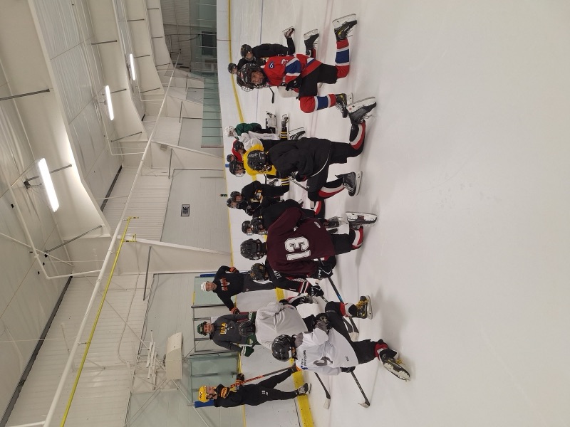 ABG coaches teaching a group of players on the ice